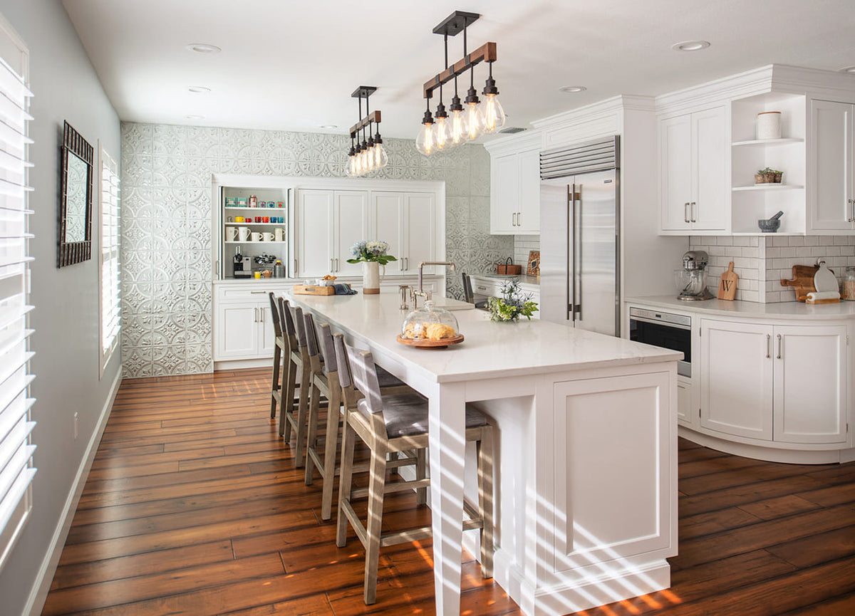 Modern white kitchen featuring a decorative pressed tin wall panel.